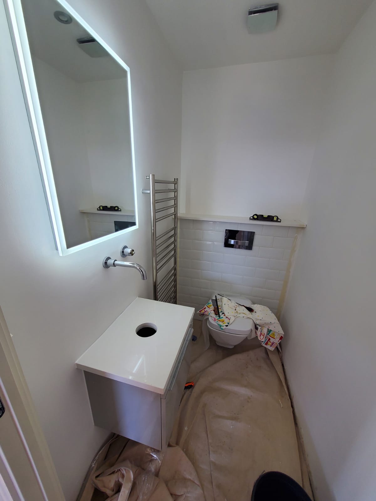 Cloakroom installation progress — LED mirror and vanity